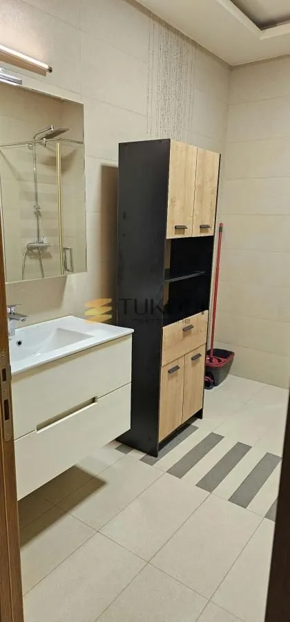 Kupatilo sa umivaonikom, ormarićem i tuš kabinom.