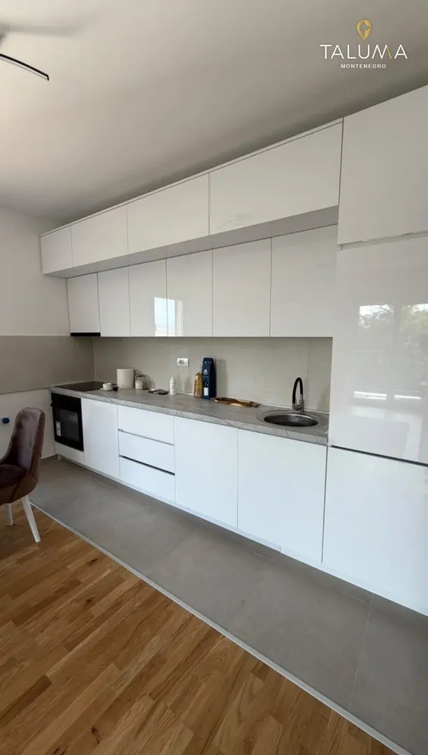 Modern white kitchen with built-in cabinetry and a sink.