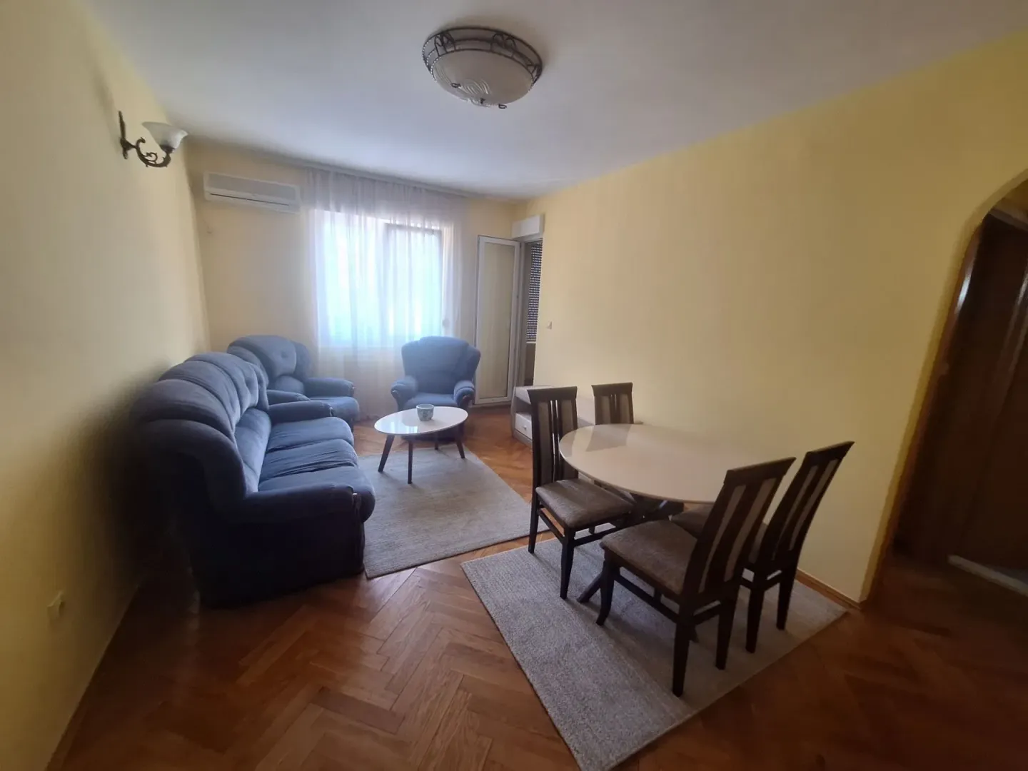 Dnevni boravak sa garniturom i trpezarijskim stolom.