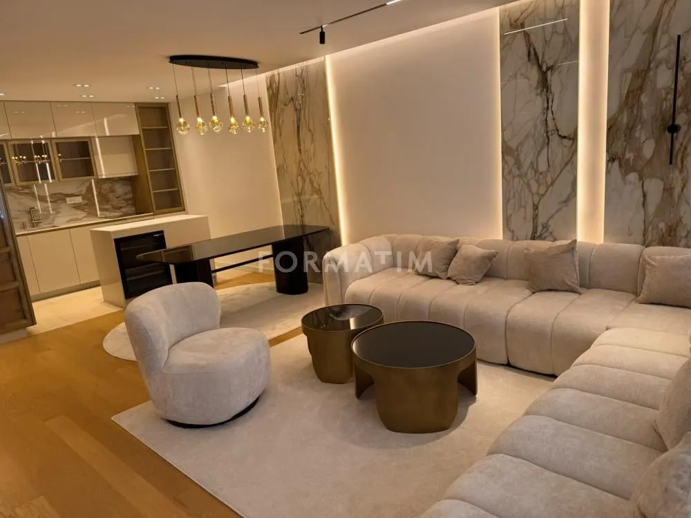 Modern living room with a sofa set and dining area in the background.