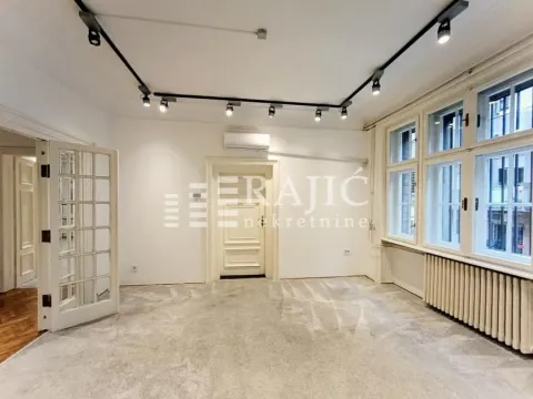 Spacious empty room with parquet flooring and large windows. - image 4