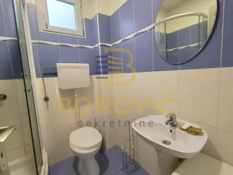 Kupatilo sa plavim pločicama, umivaonikom, ogledalom i WC šoljom. - image 10