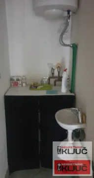 Small bathroom with a washbasin and a water heater on the wall. - image 9