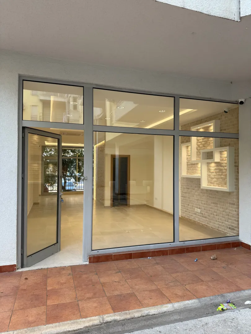 Entrance to a commercial space with a glass storefront and an open door.