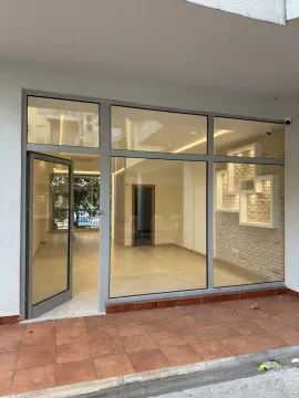 Entrance to a commercial space with a glass storefront and an open door. - image 7