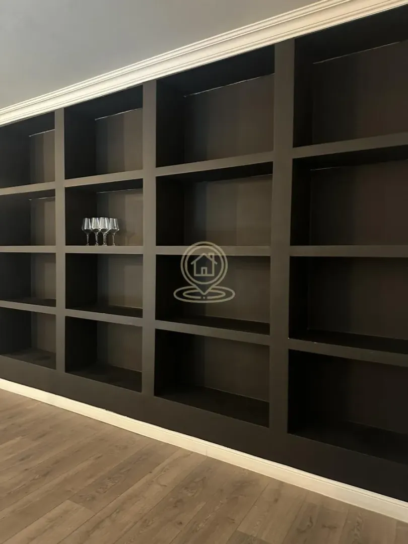 Large dark wall shelving unit with open compartments.