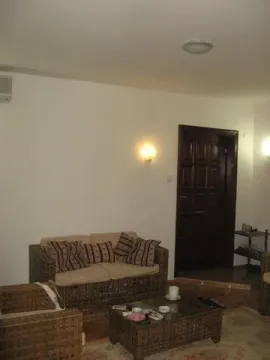 Living room featuring wicker furniture and a wooden door. - image 16