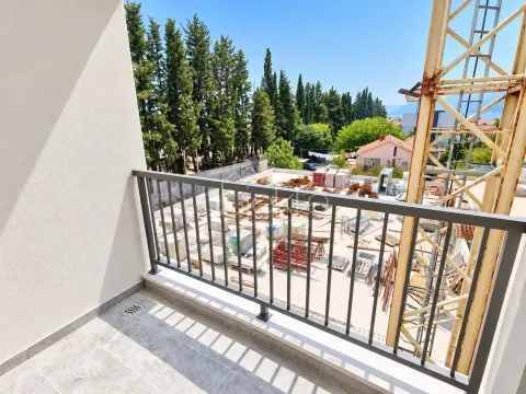 Pogled sa balkona na okolno zelenilo i gradilište sa kranom. - image 3
