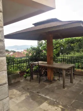 Paved terrace featuring a wooden table with an integrated canopy. - image 6