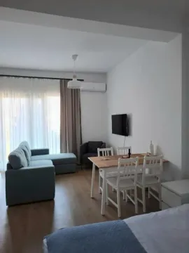 Living room with a sofa set, dining table, and terrace access. - image 2
