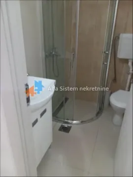 Smaller bathroom with a shower cabin, washbasin, and toilet. - image 8