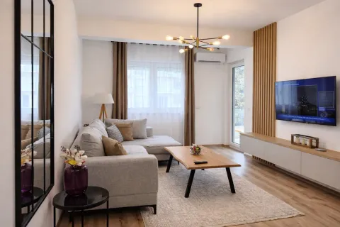 Modern and bright living room with a sectional sofa, wooden coffee table, and TV. - image 8