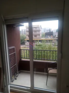 Pogled kroz balkonska vrata na terasu i okolne zgrade. - image 3
