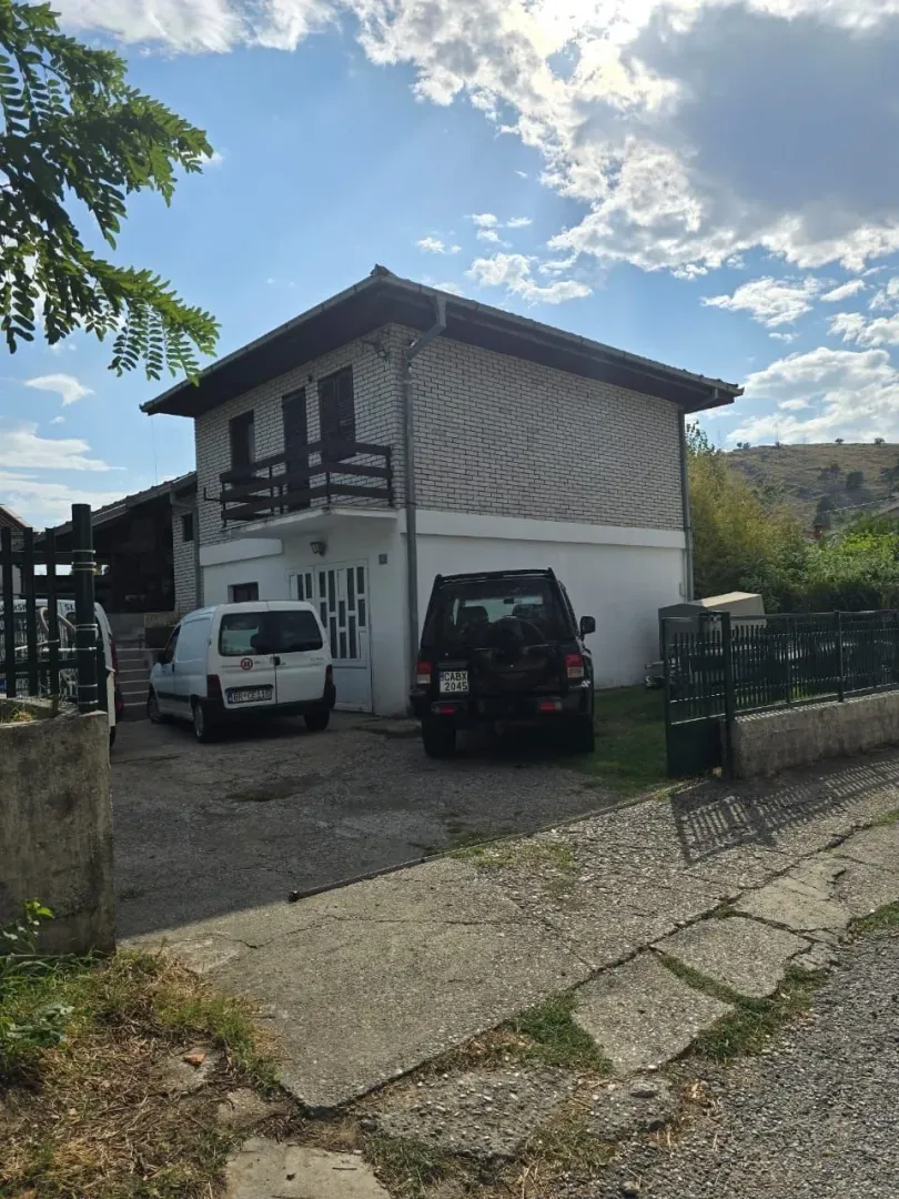 Dvospratna kuća sa dvorištem i parkingom.