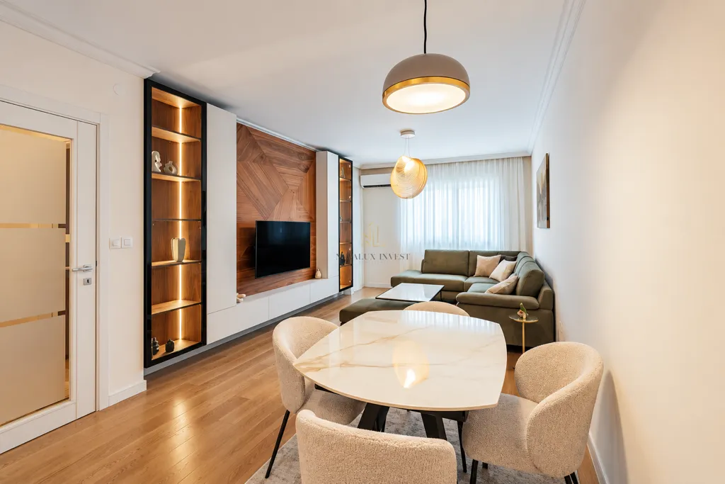 Living room with a sofa set, dining table, and TV unit with illuminated shelves.