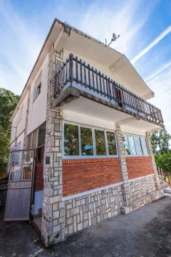 Spoljašnji izgled kuće sa kamenom fasadom i balkonom. - image 4
