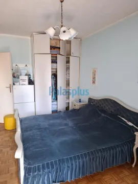 Spavaća soba sa bračnim krevetom, ormarom i parketom na podu. - image 8