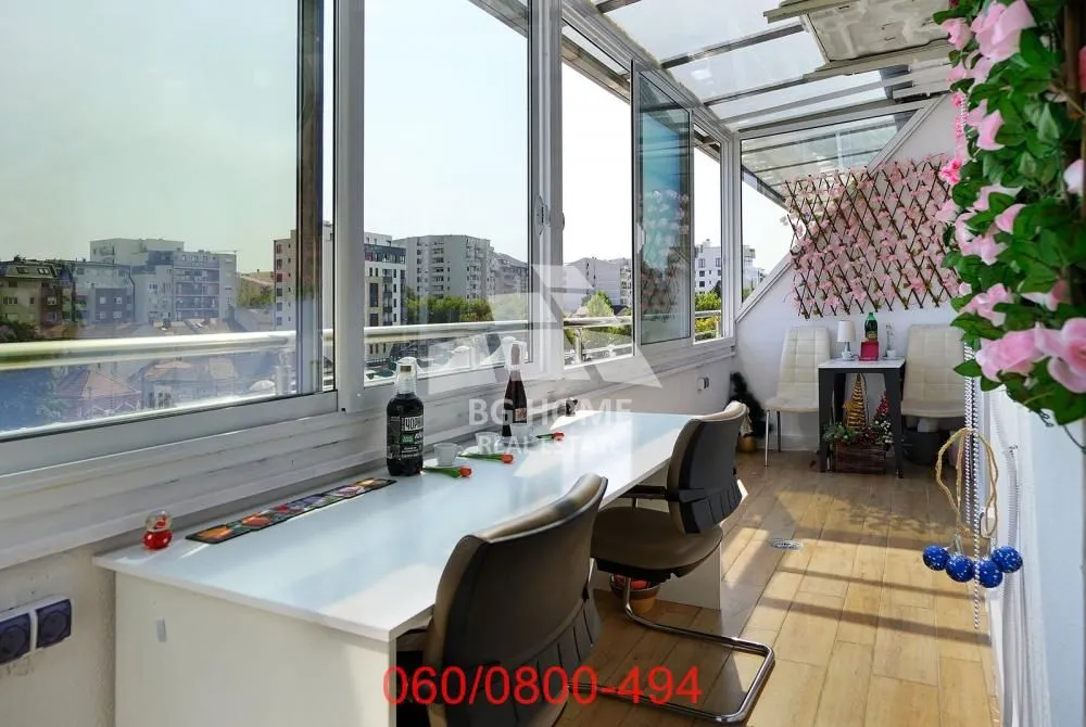 Glazed terrace with a work desk and city view.