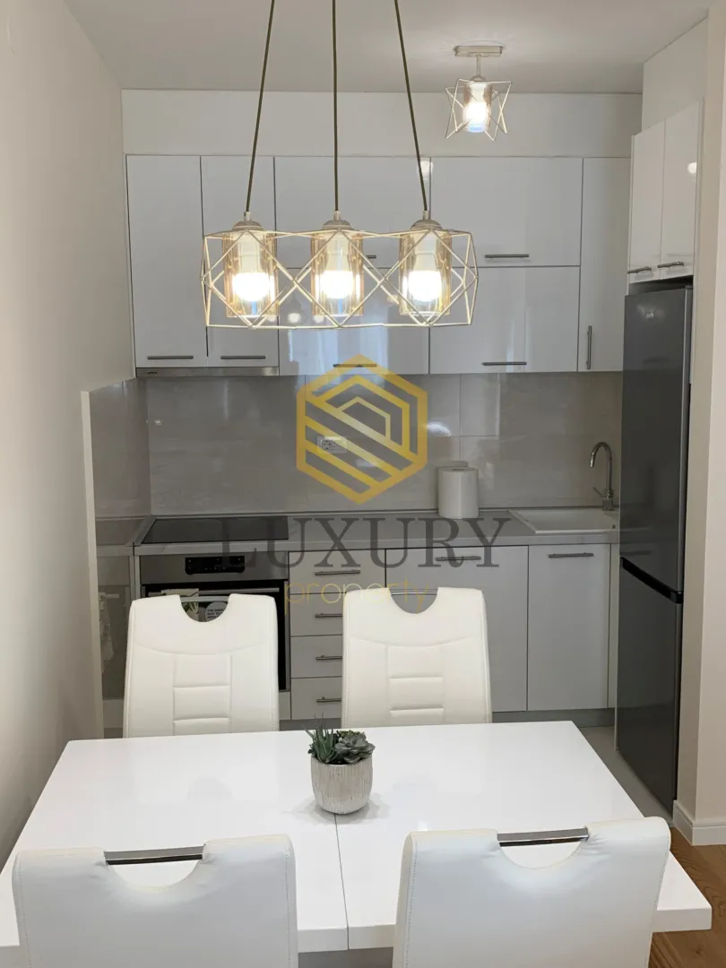 Modern kitchen with a dining table and white cabinets.