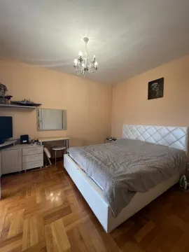 Spavaća soba sa bračnim krevetom, komodom, radnim stolom i parketom na podu. - image 11