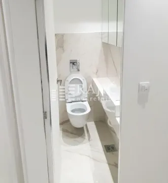 View of a modernly equipped bathroom with white sanitary ware and marble tiles. - image 7