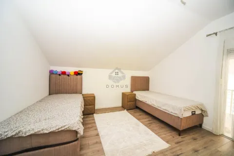 Bedroom with two single beds and sloped ceilings. - image 4