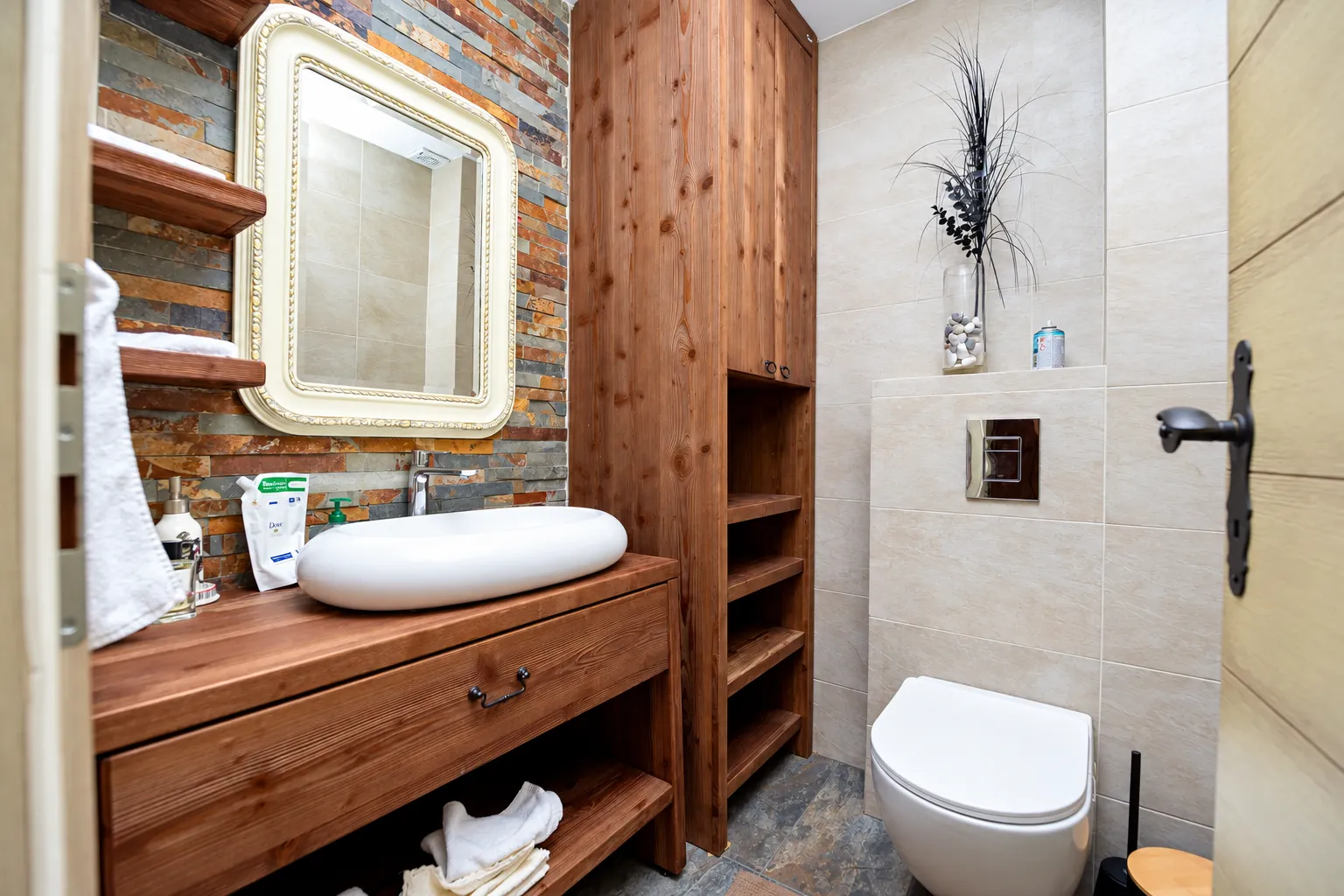 Bathroom with wooden furniture, washbasin, and toilet.