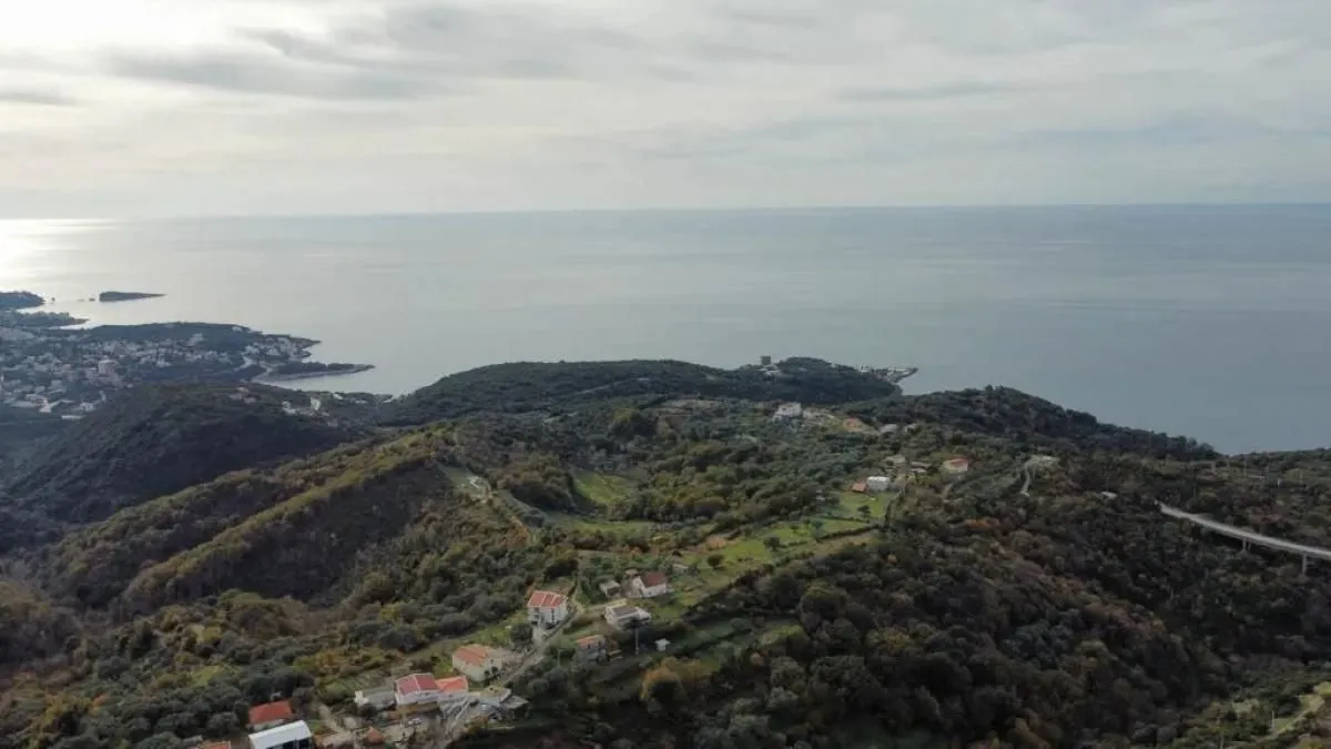 Pogled iz vazduha na prirodu, naselje i obalu mora.