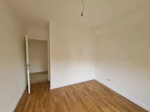 Prazna neopremljena soba sa laminatom na podu i otvorenim vratima. - image 5