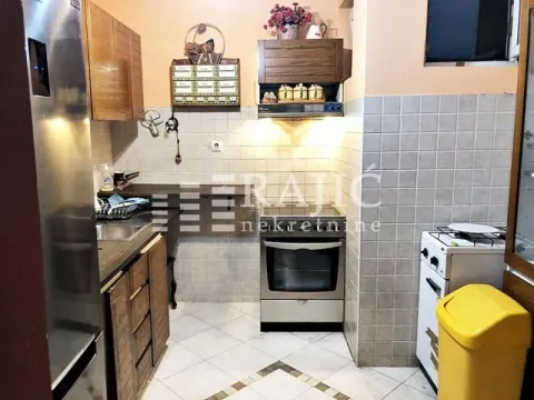 Small kitchen with wooden units and built-in appliances. - image 8