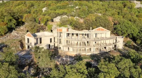 Pogled iz vazduha na nedovršeni objekat u izgradnji okružen zelenilom. - image 2
