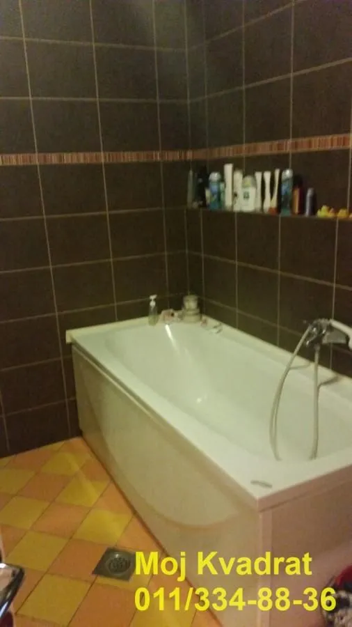 Kupatilo sa kadom obloženom tamnim pločicama.