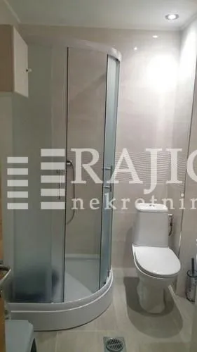 Manje kupatilo sa tuš kabinom i toaletom.
