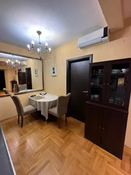 Trpezarija sa stolom, stolicama, velikim ogledalom i tamnim drvenim ormarom. - image 12