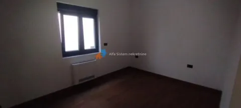 Prazna soba sa tamnim drvenim podom i jednim prozorom. - image 6