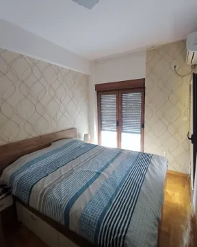 Namještena spavaća soba sa bračnim krevetom, drvenim podom i prozorom. - image 4