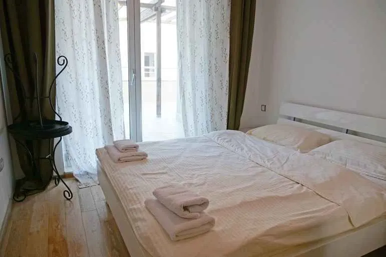 Spavaća soba sa bračnim krevetom i izlazom na terasu.