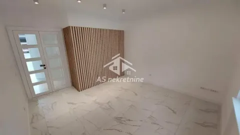 Prazna prostorija sa belim keramičkim pločicama i drvenim zidnim panelom. - image 6