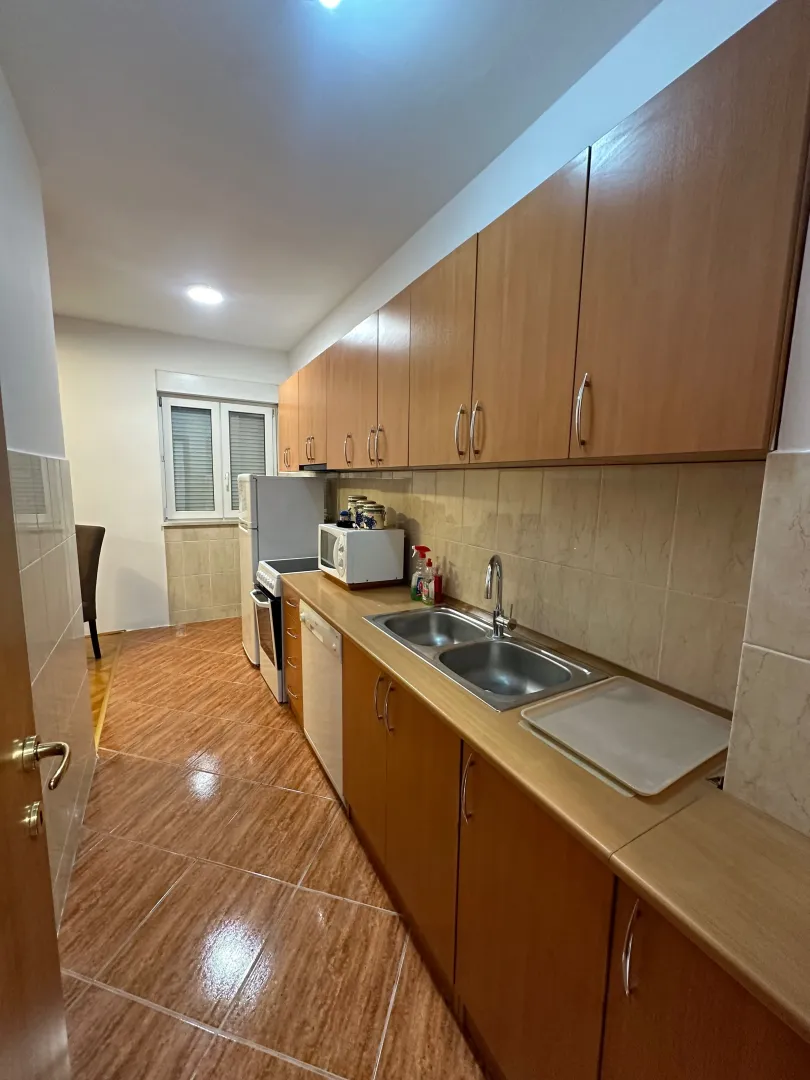 View of the kitchen with wooden cabinets, a sink, and built-in appliances.