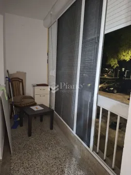 Small enclosed balcony with glass sliding doors and a small piece of furniture. - image 6