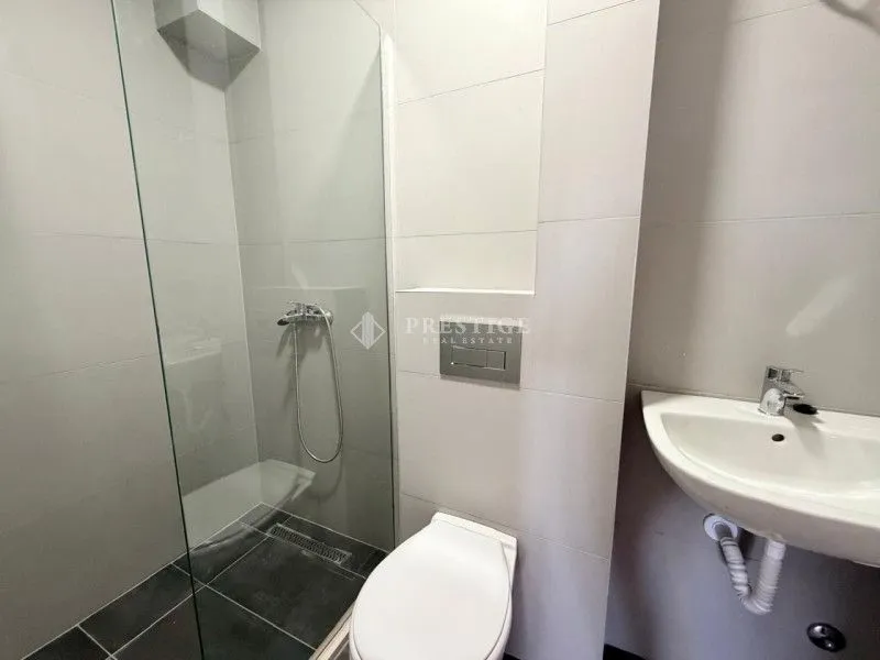 Moderne kupatilo sa tuš kabinom, toaletom i umivaonikom.