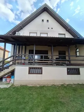 Pogled na zadnju stranu kuće sa natkrivenom verandom i travnjakom. - image 11