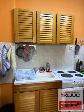Manja kuhinja sa drvenim elementima, sudoperom i šporetom. - image 8