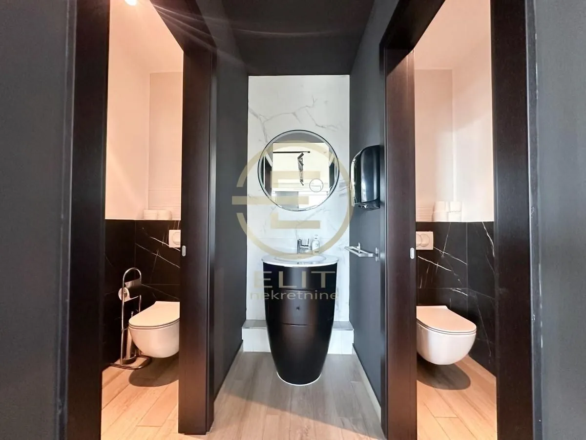 Modern restrooms with a washbasin and black-and-white ceramic tiles.
