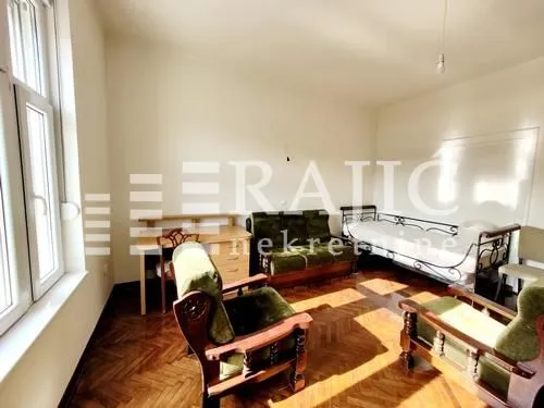 Living room with seating furniture and wooden parquet flooring.