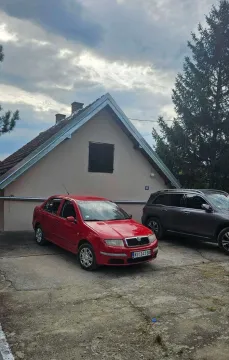 Pogled na spoljašnjost kuće sa dvorištem i parkiranim automobilima. - image 9