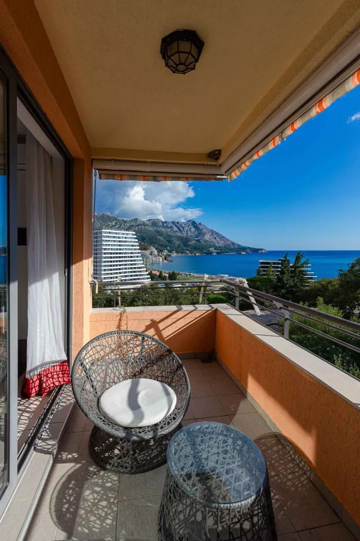 Natkriveni balkon sa garniturom za sedenje i pogledom na more.