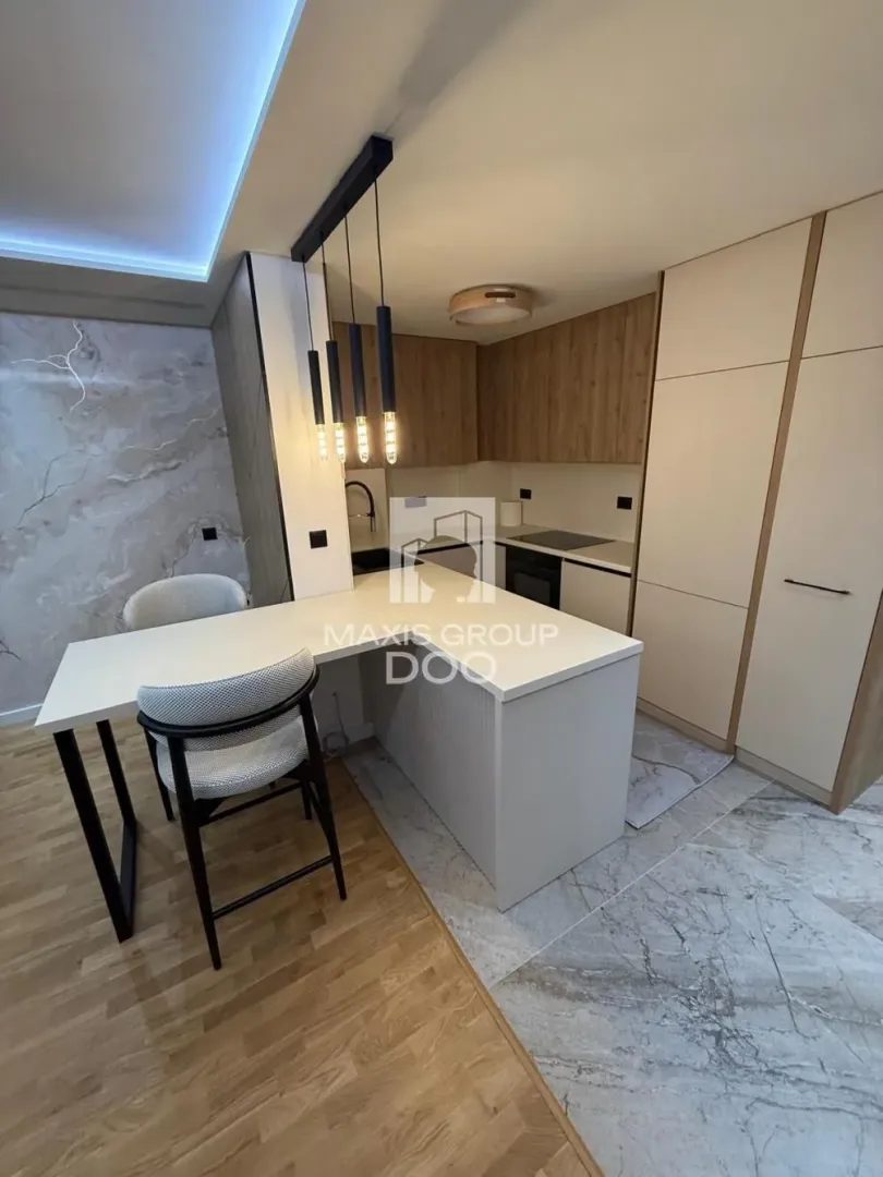 Modern kitchen with a breakfast bar, dining table, and built-in appliances.