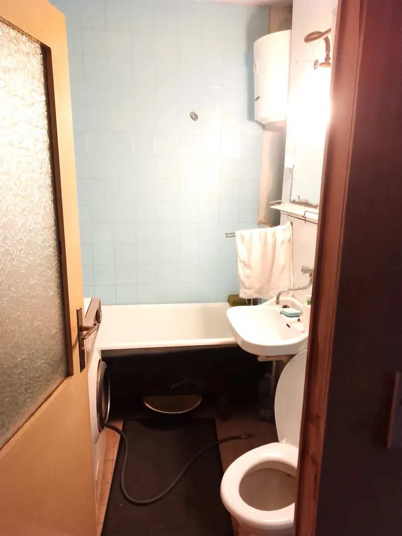 Pogled na manje kupatilo sa kadom, umivaonikom i toaletom.