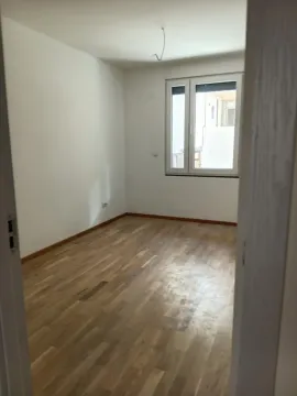 Prazna soba sa parketom i belim zidovima. - image 4